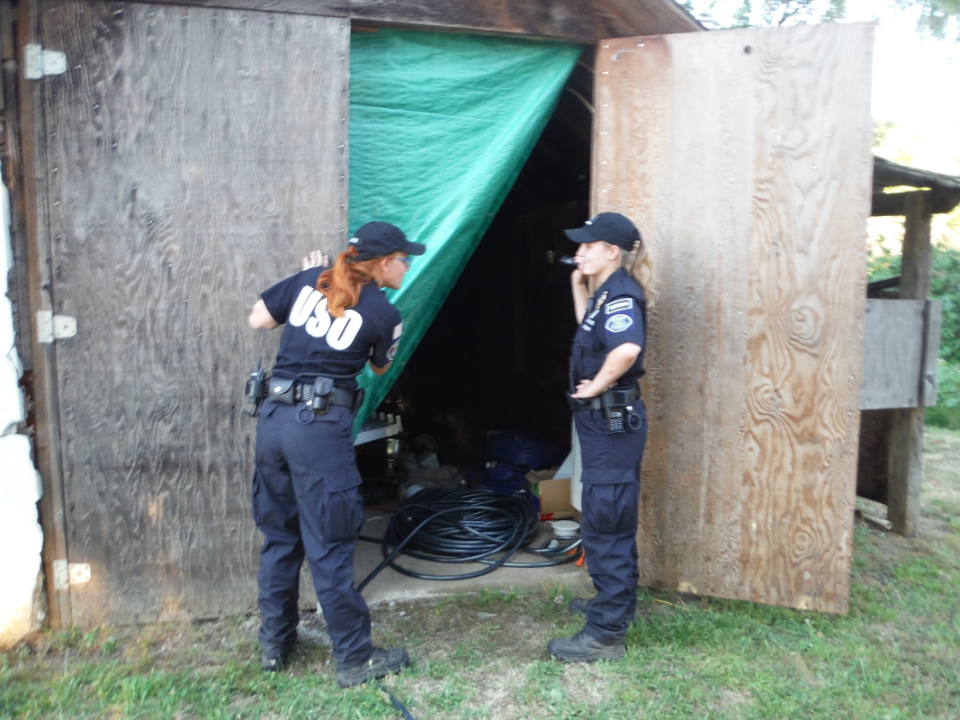 United Security Operations agents investigate a shed for suspicious activity.